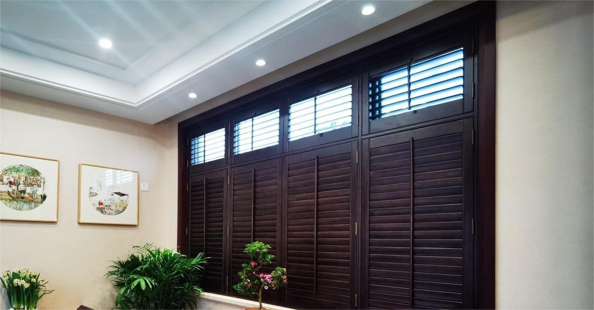 Wood plantation shutters installed in a bright, dry living room interior