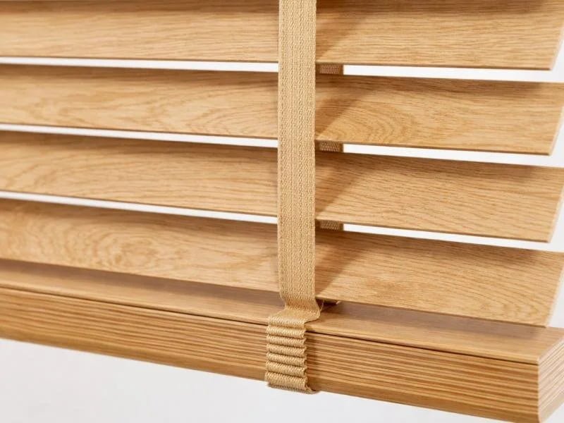 Close-up of wood venetian blind slats showing 25mm width option in natural basswood finish
