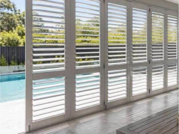 Outdoor covered area with aluminium plantation shutters