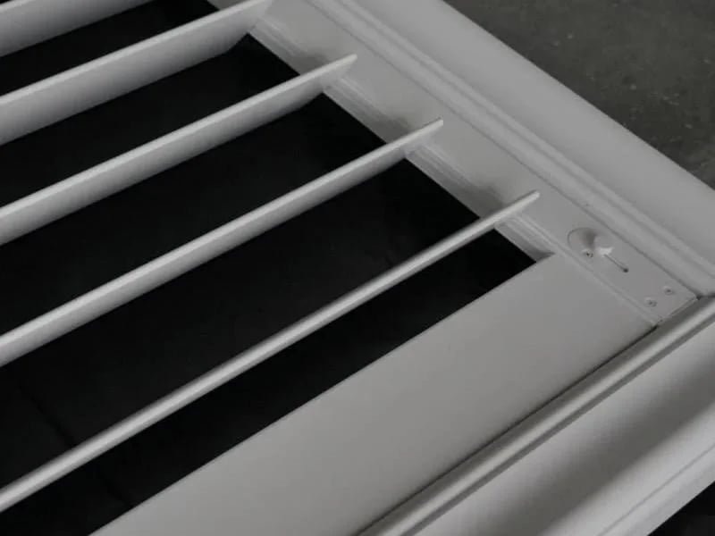 Aluminium plantation shutter close-up showing gear tilt rod and integrated rail design